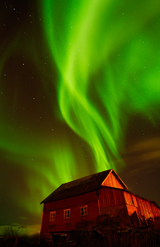 Northern lights over a red barn on Kvaløya west of Tromsø © Gaute Bruvik