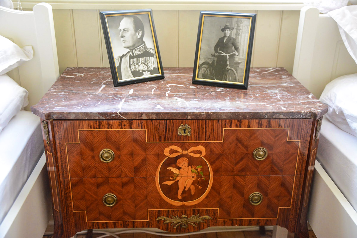 Kong Olav's portrait situated on a chest of draws. Eva has included many original items from the old shop © Knut Hansvold