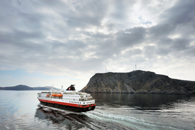 The Hurtigruten sailing past the Havøygavlen cliffside before calling at Havøysund. The photo is taken from the south bound ship when meeting the north bound ship just south of Havøysund © Jarle Wæhler/Statens vegvesen