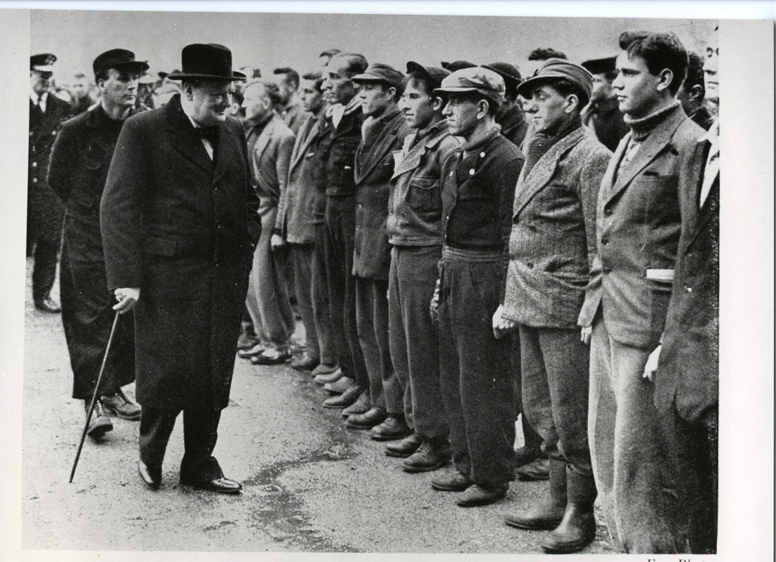 Daværenden marineminister Winston Churchill inspisererer tropper som kom hjem fra slaget i Narvik med sivile klær. En av disse sendte vantene tilbake til Narvik med "takk for lånet". © Narvik Krigsmuseum