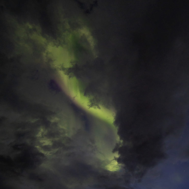 The Northern Lights fight their way through the clouds © Lofoten Aktiv