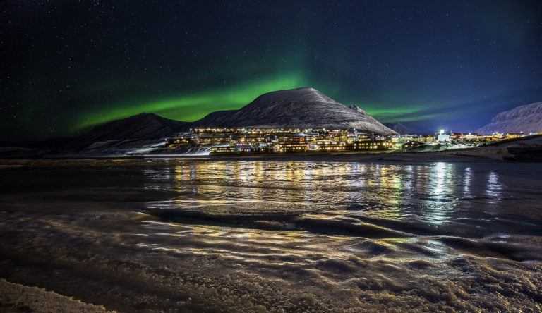 The Northern Lights, the town and the fjord © Terje Nilssen