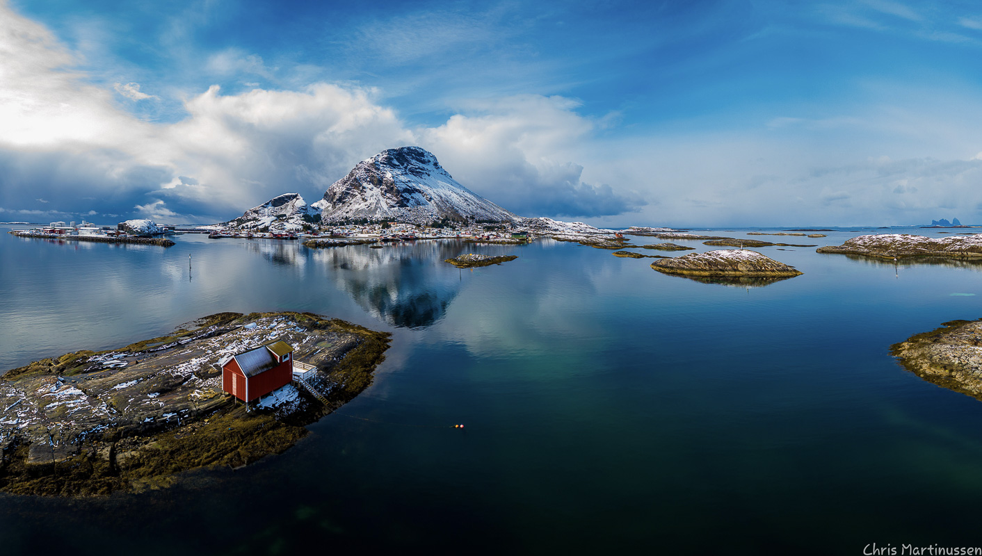 Lovund on a serene winter's day. Vintage picturesque in the front, a lovely fishing village under the mountain, industry at the far left and the island of Træna afar on the right © Chris Martinussen