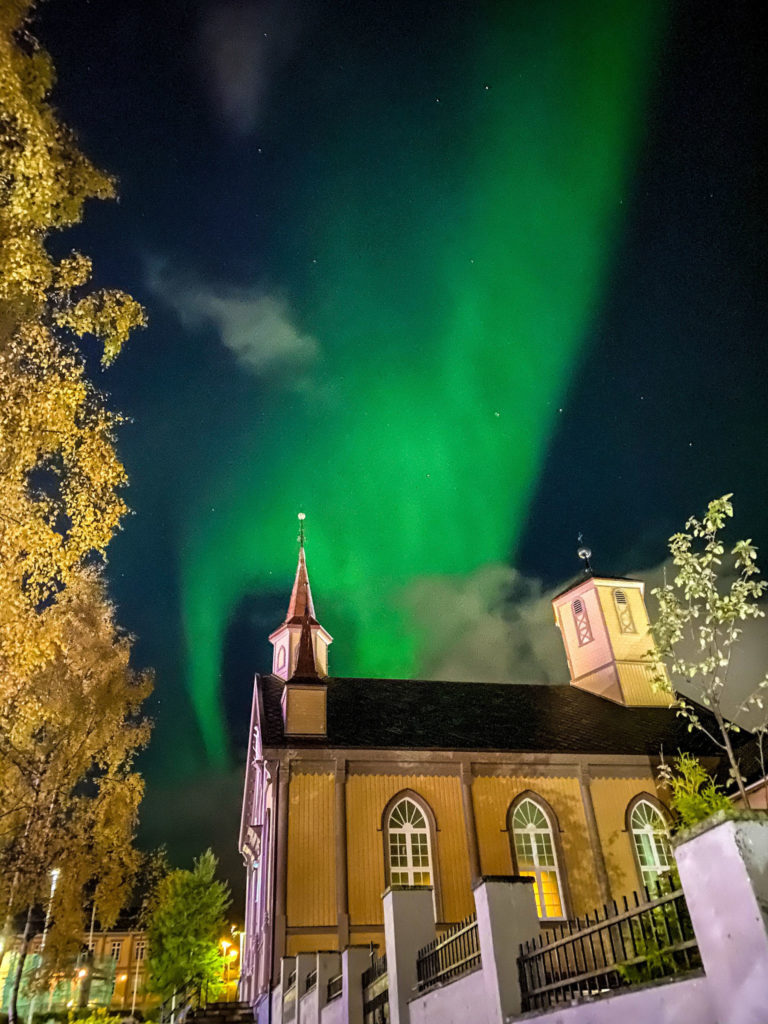 Vår frue kirke er verdens nordligste domkirke, for anledningen lyst opp av nordlyset © Knut Hansvold