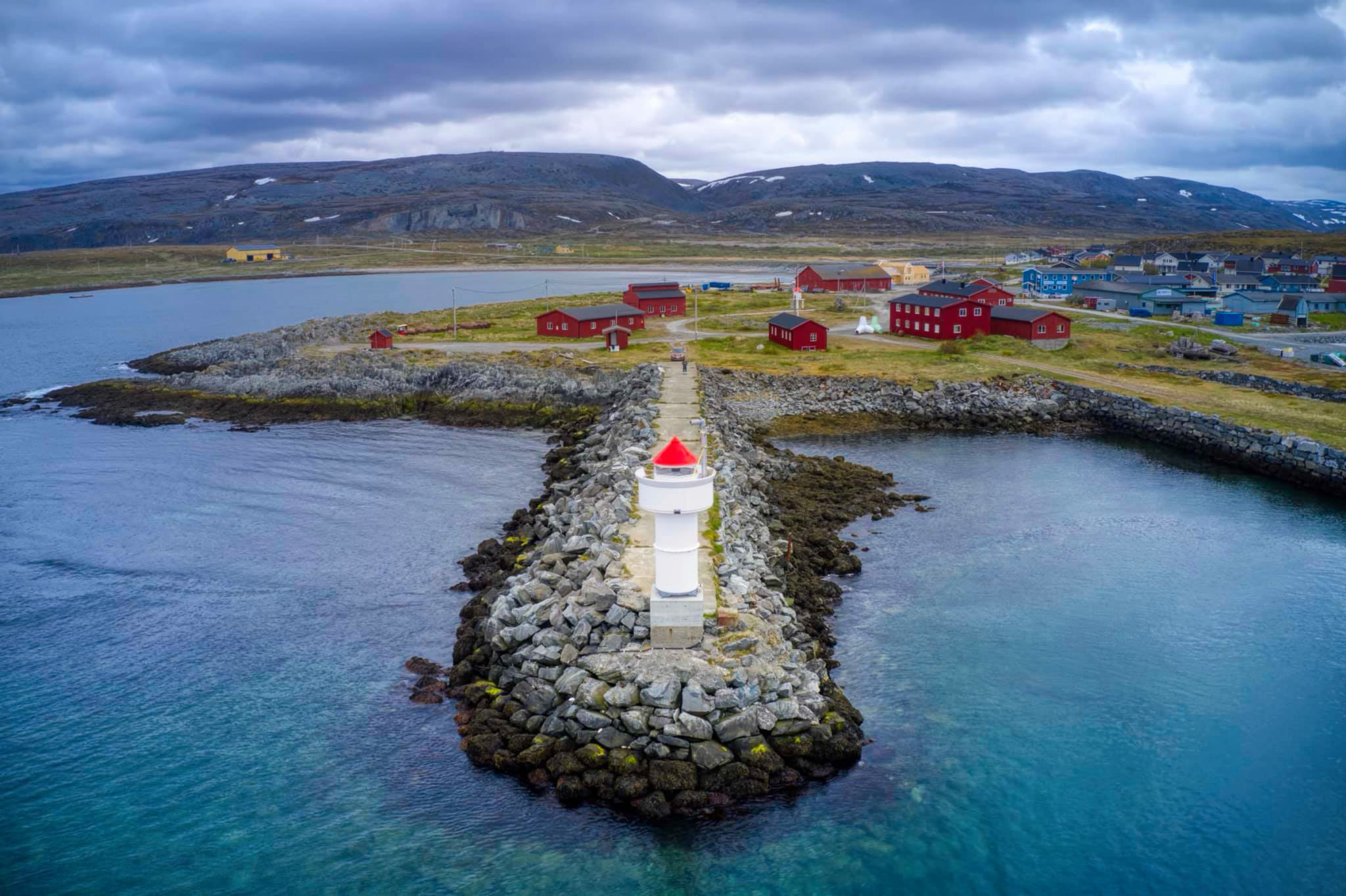 Berlevåg with the red buildings that constitue the Harbour Museum. The entrance is next to the white and green tetrapodes © Havnemuseet i Berlevåg
