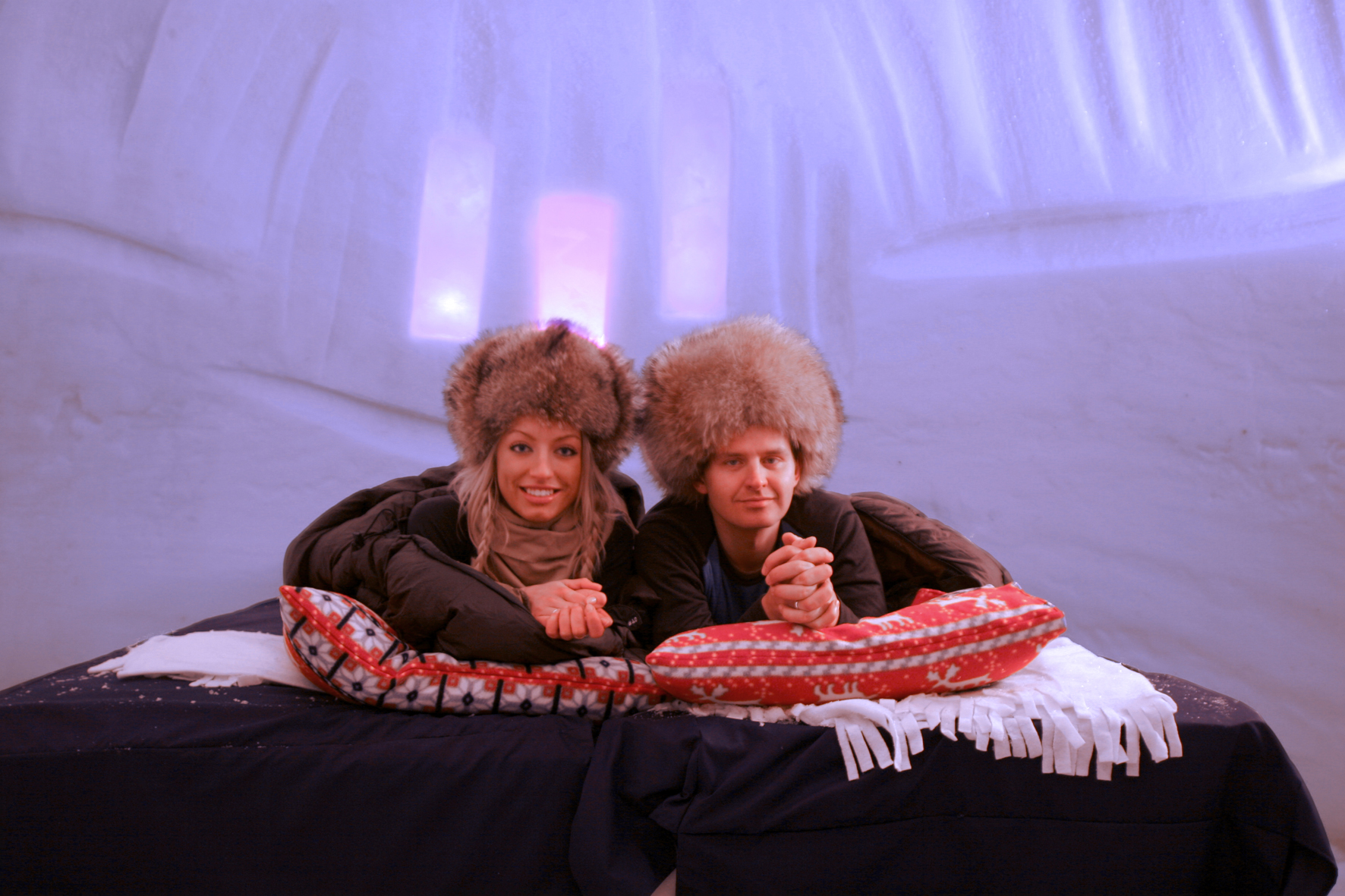 A couple laying on the bed in Kirkenes Snow Hotel.