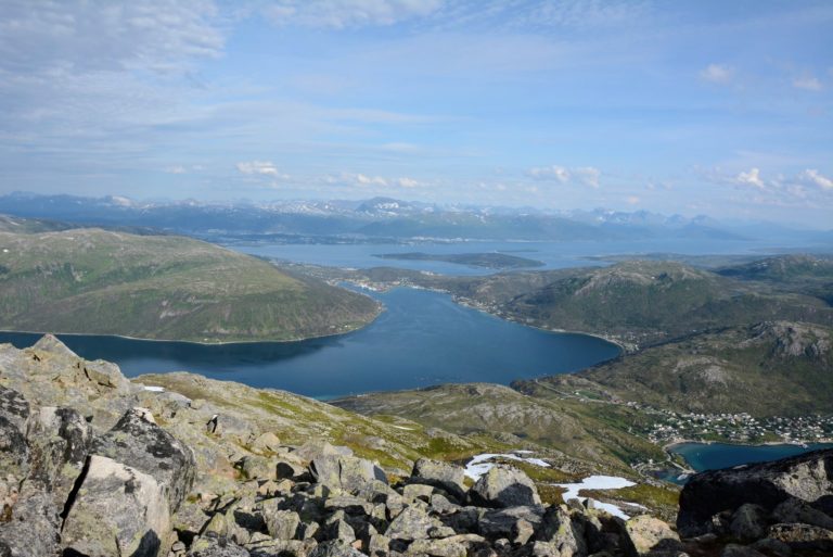 View from the top of Mount Buren. The fjord in the front is Kaldfjord, Tromsø is in the centre. Behind the majestic Mount Tromdalstind, the Lyngen Alps are visible in the far back © Knut Hansvold