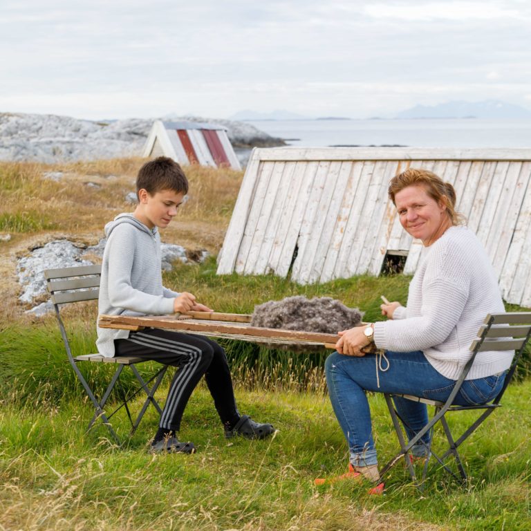 Olaug form Givær are learning the next generation the tradition of using the down harp. It is used to remove remains of eggshell and seaweed by hand, in order to keep the down soft and fluffy. Photo: Kathrine Sørgård