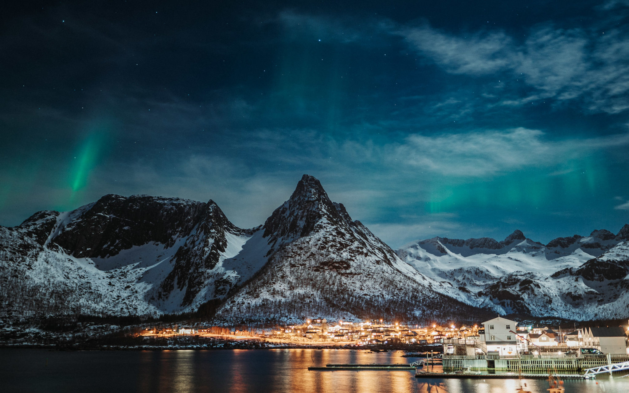 The ocean side village of Mefjordvær a moonlit night with fluttering northern lights curtains © Kristoffer Vangen