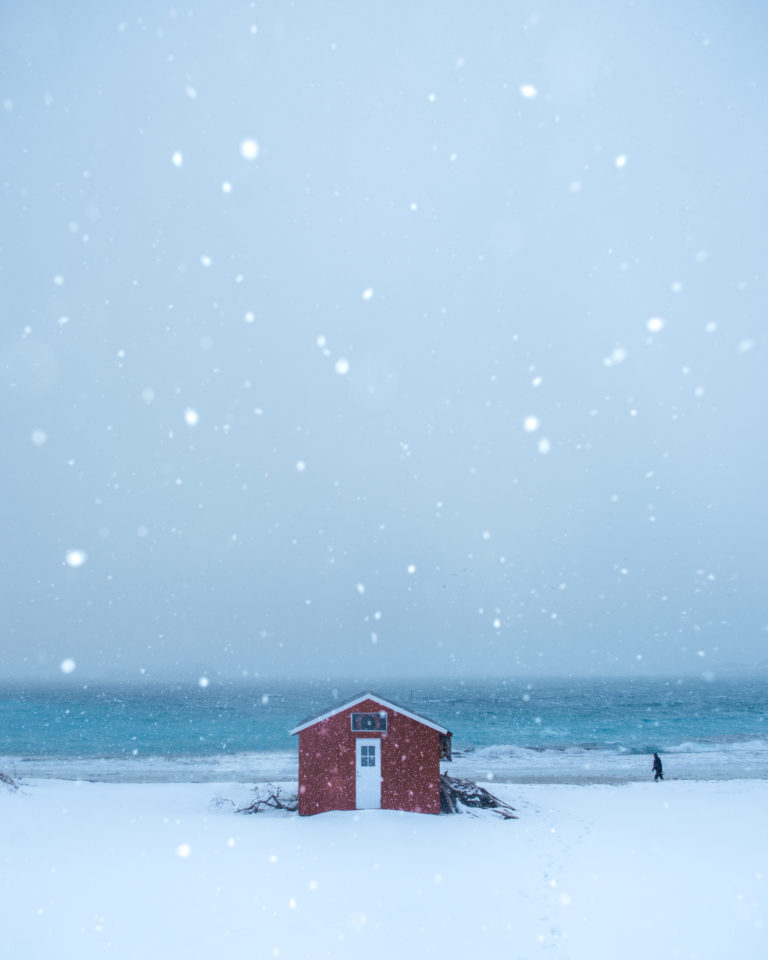 Sea, boathouse and snow showers on Senja Island © Kristoffer Vangen