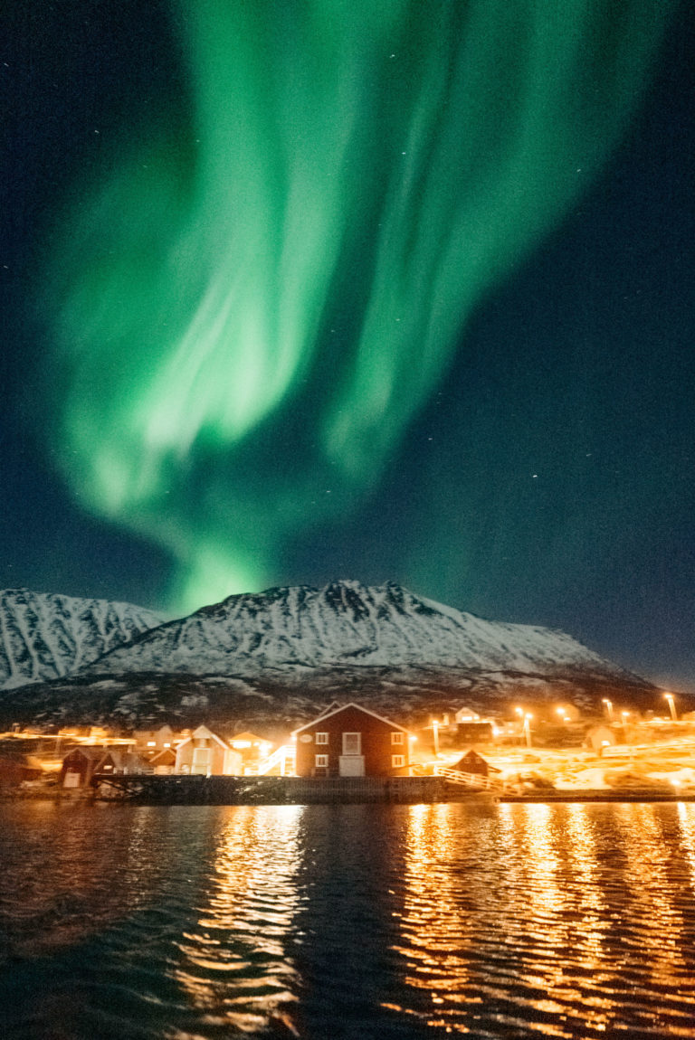 The Northern Lights are flooding over the Grytøya peaks © Emmet Sparling / Seil Bifrost