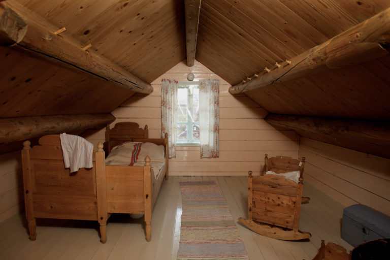 The bedroom on the attic at Gamslett farm. Note the hooks on the right beam, they are made out of empty spools © Ola Solvang / Nord-Troms Museum