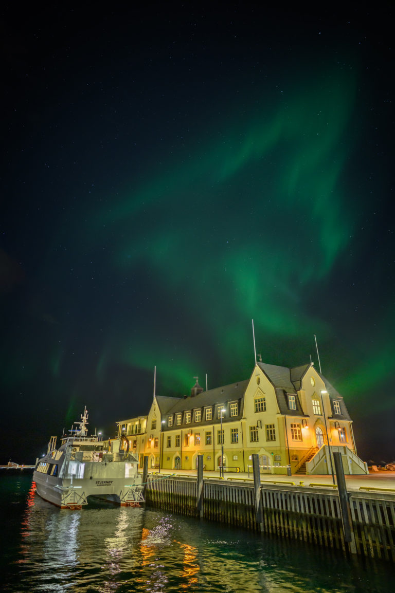 On a quiet autumn evening, the Northern Lights appear over the harbor terminal in Harstad © Arne Widding