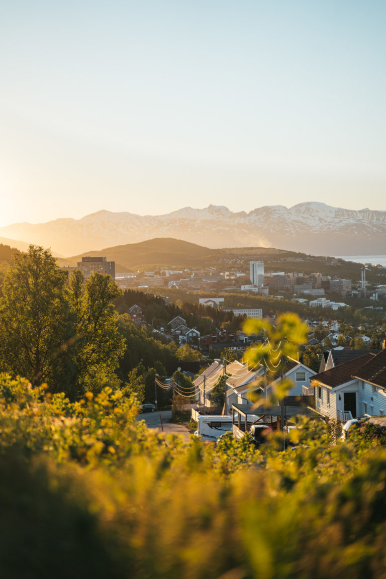 View from the top of Tromsø Island looking north towards the island of Ringvassøy, with the light of the midnight sun coming in from the left © David Jensen / @jensenmedia