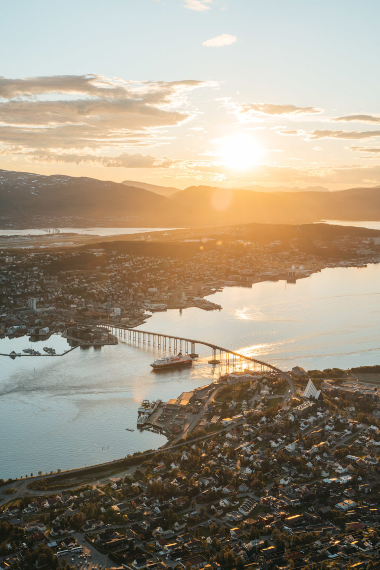 It's almost twelve, and the southbound Hurtigruten passes under the Tromsø Bridge © David Jensen / @jensenmedia