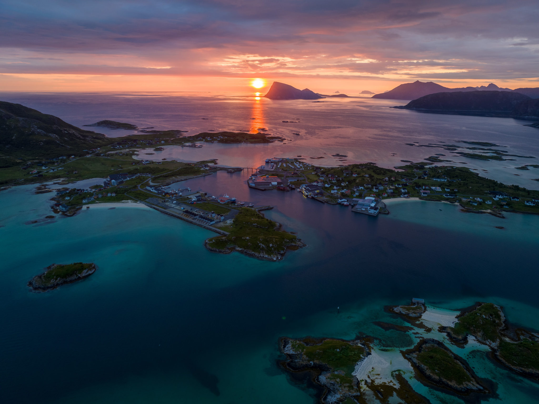 The midnight sun battles with the clouds over the rocky island of Håja, seen from Sommarøy southwest of Tromsø. © Vegard Stien/Raw Studios