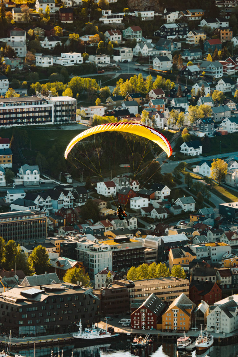 The paraglider is probably feeling the autumn in the air as they glide over Tromsø © Vegard Stien / Raw Studios