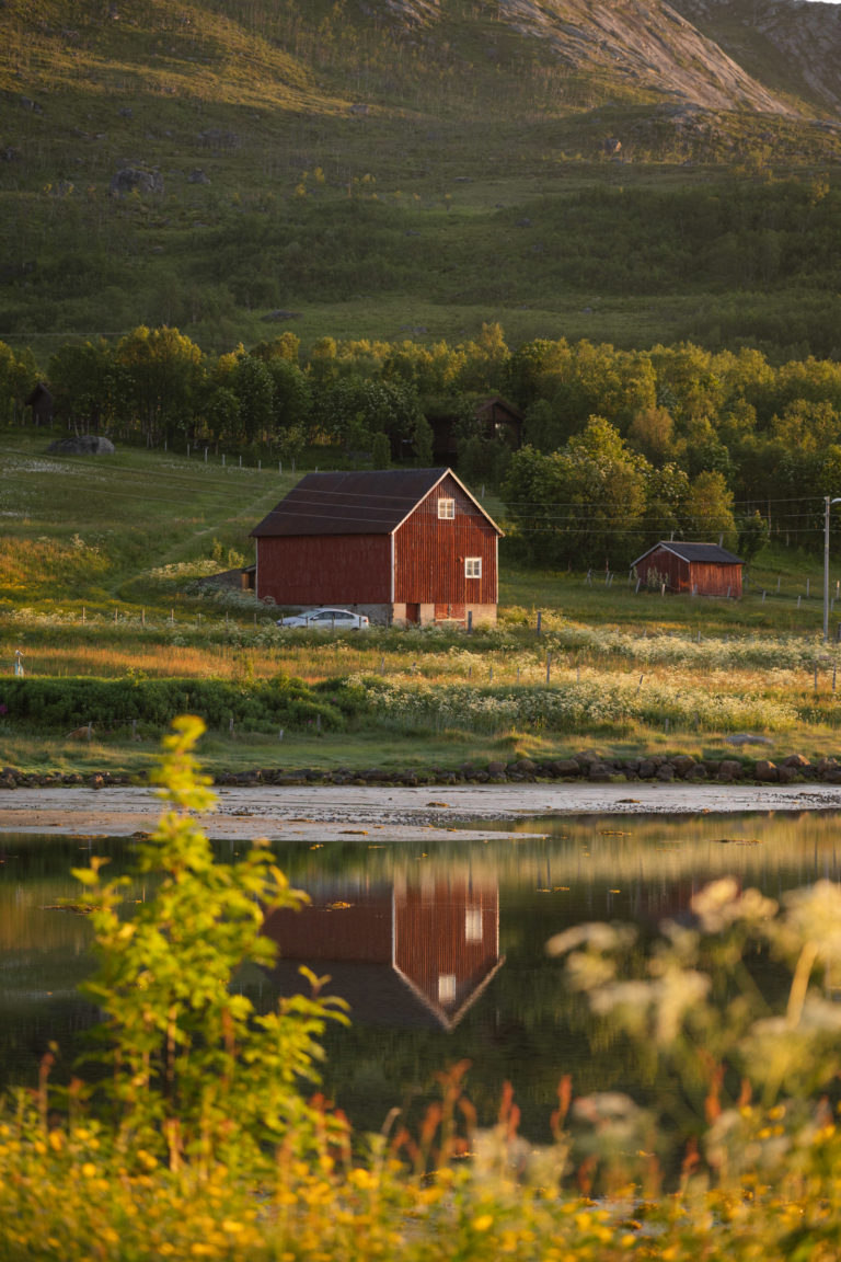 A barn reflects in the fjord on the island of Kvaløya in soft night light © Marie Nystad Helgesen