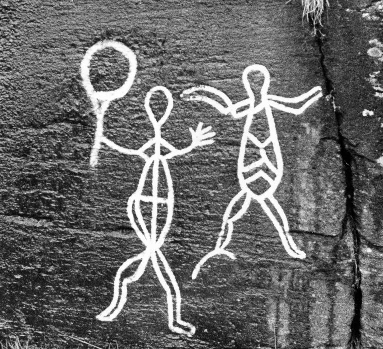 Two human figures at Skavberg in the south of Kvaløya. One is holding something that might be a shaman’s drum—or perhaps a fishing tool © Knut Dyvik, 1959 / fotoarkiv@perspektivet.no