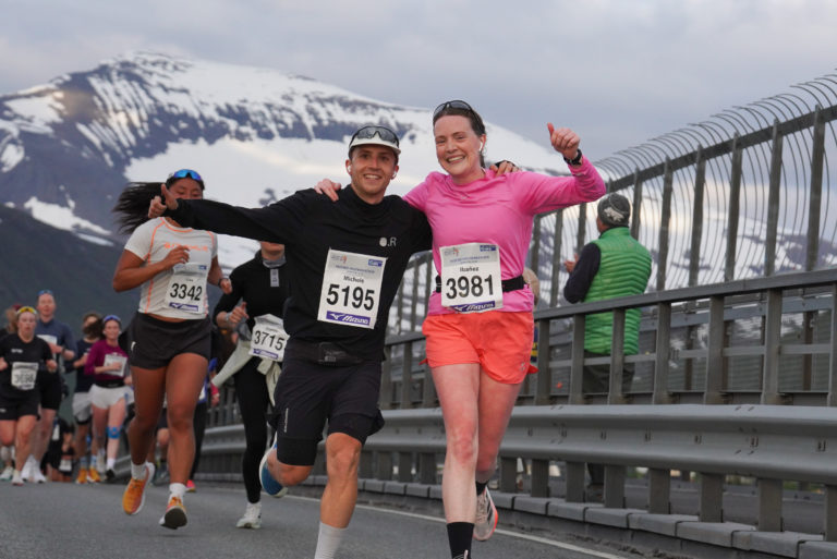 Marathon friends crossing the Tromsø Bridge, with the 1,238-metre-high Mount Tromsdalstinden in the background. © Pål Jakobsen / Midnight Sun Marathon