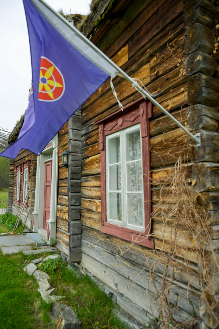 The Sokkelvik House from 1850 was moved here in the 1990s, and now serves as an exhibition space in summer. In the Kven village of Nordreisa, it’s only natural to have a Kven flag on the wall. © Knut Hansvold / Northern Norway Tourist Board